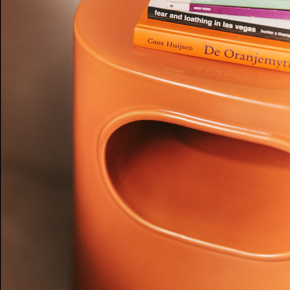 close up of the glossy orange bed side table from hkliving design house with books placed apon it