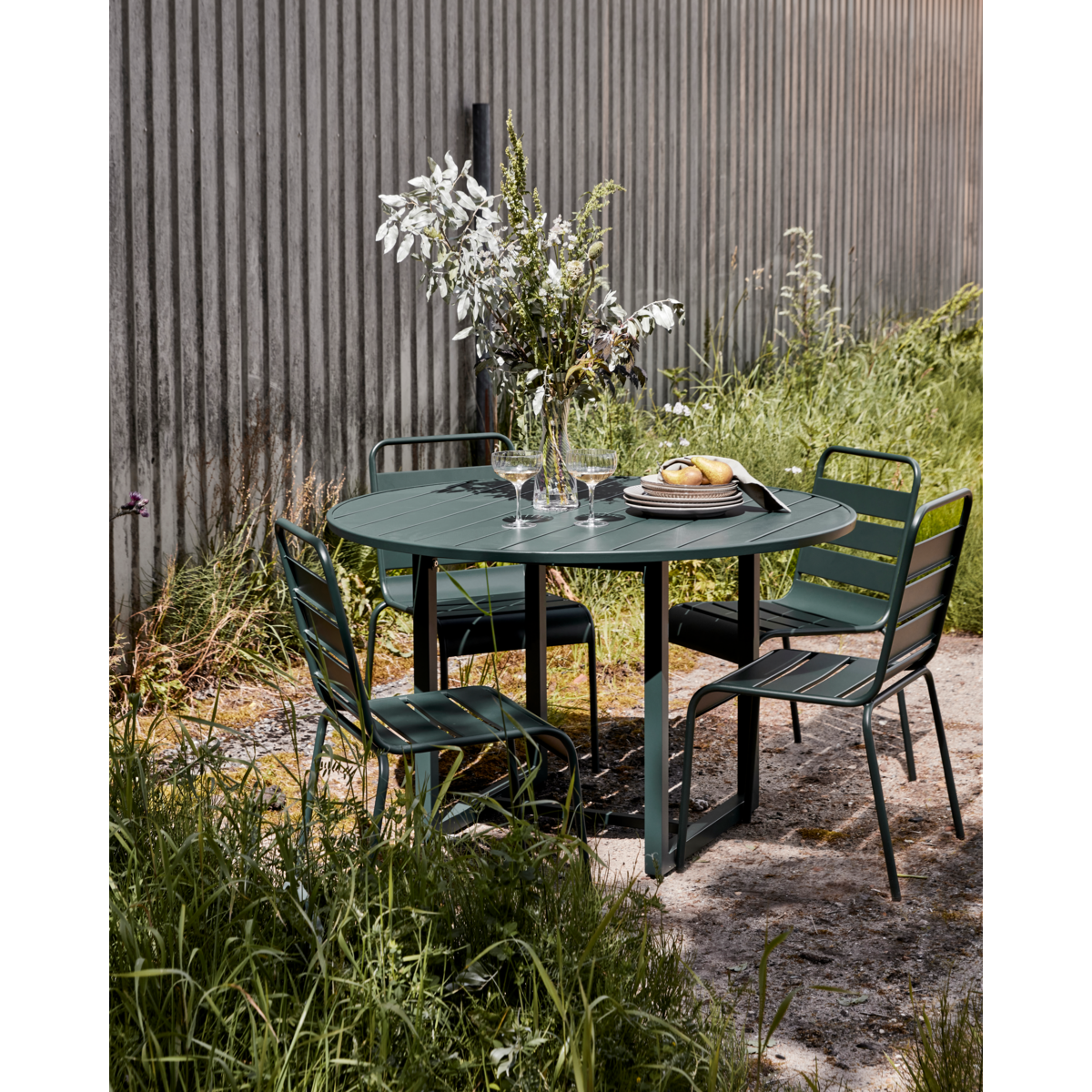 Round green iron outdoor table by House Doctor styled with matching chairs – North Home