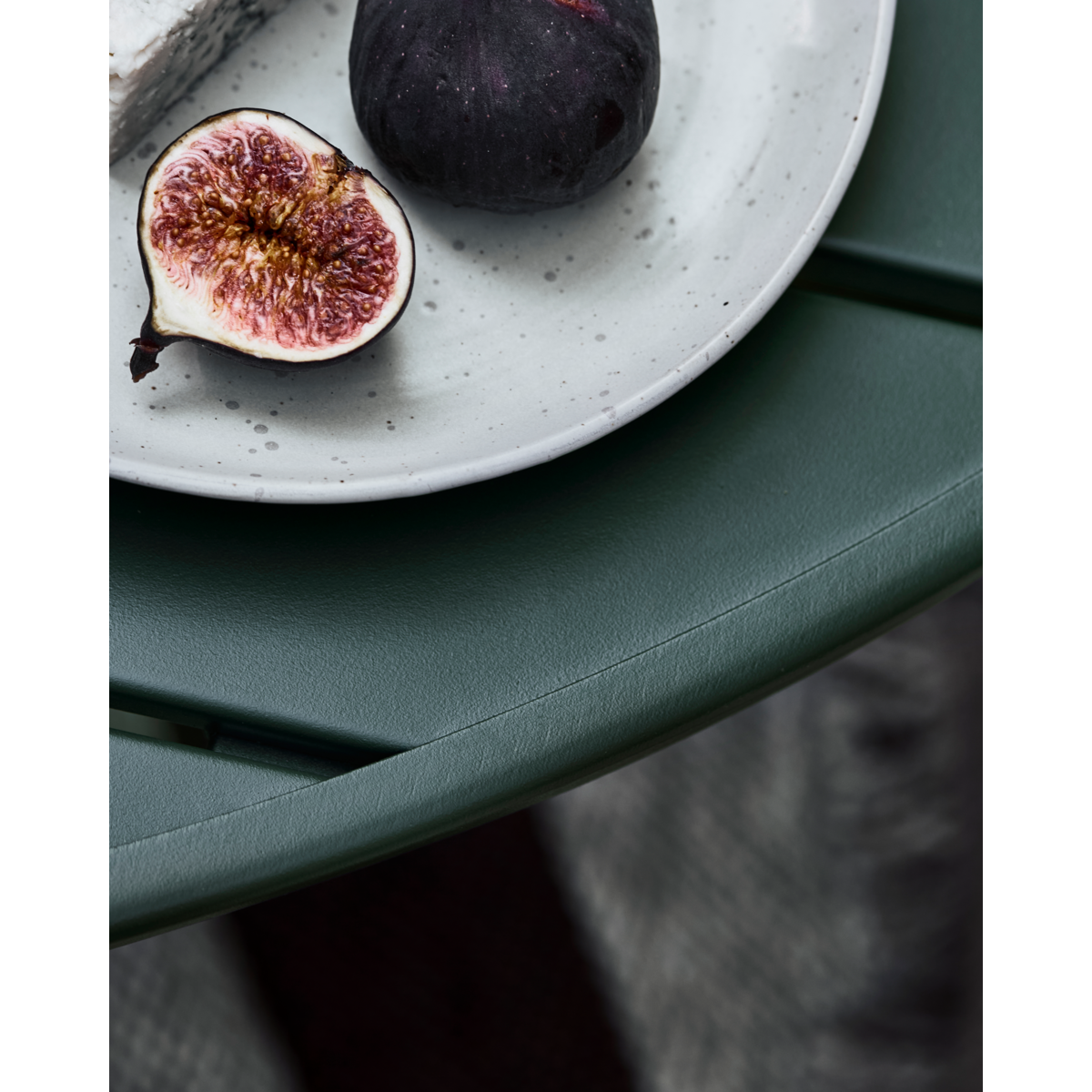 Low round outdoor table with slatted surface in matte dark green finish