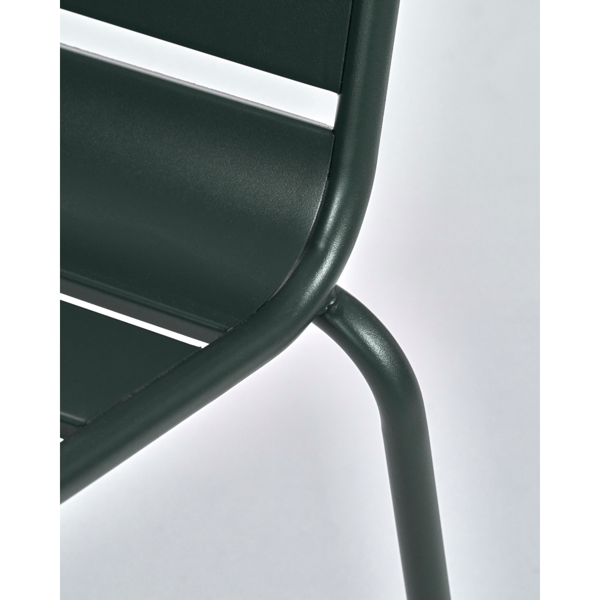 Detail of matte green iron slats on outdoor chair for garden dining
