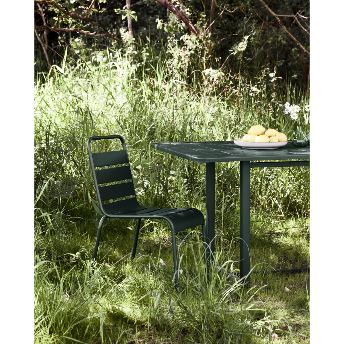 House Doctor Helo chair styled in grass setting next to green table
