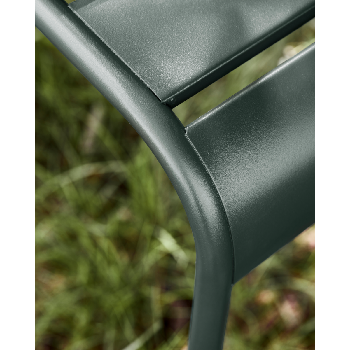Outdoor chair with slim iron frame and slatted back in timeless dark green
