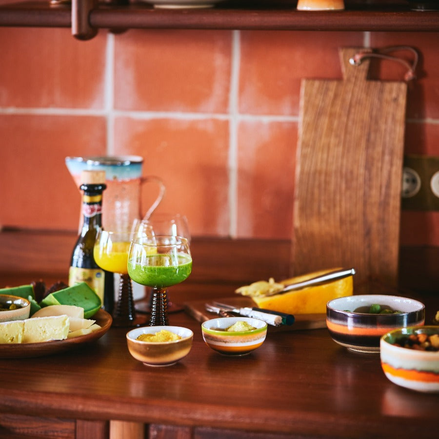 a collection of hkliving crockery on a kitchen worktop in a multitude of bright and joyful colours and commbinations