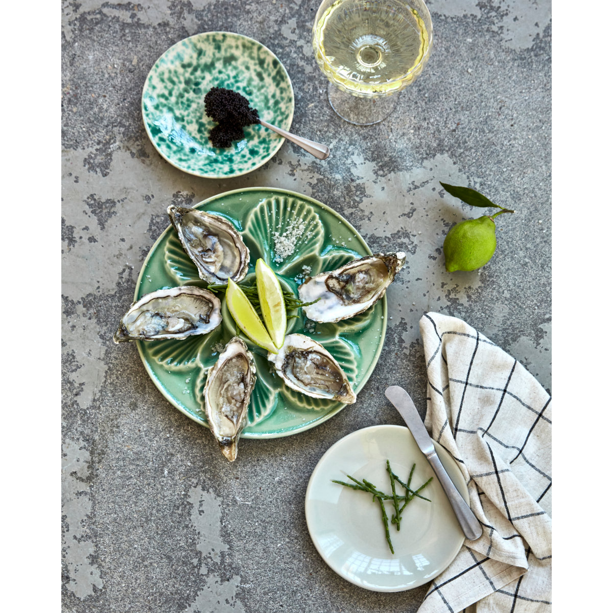 Lifestyle image of green Diva dish styled with oysters and lime – elegant entertaining