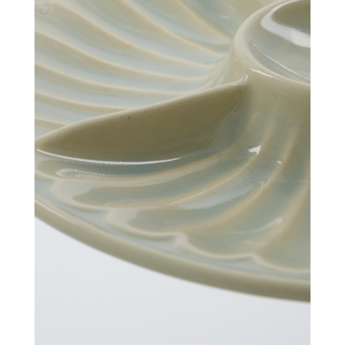 Close-up of glossy glazed stoneware dish with ridged segments – North Home tableware