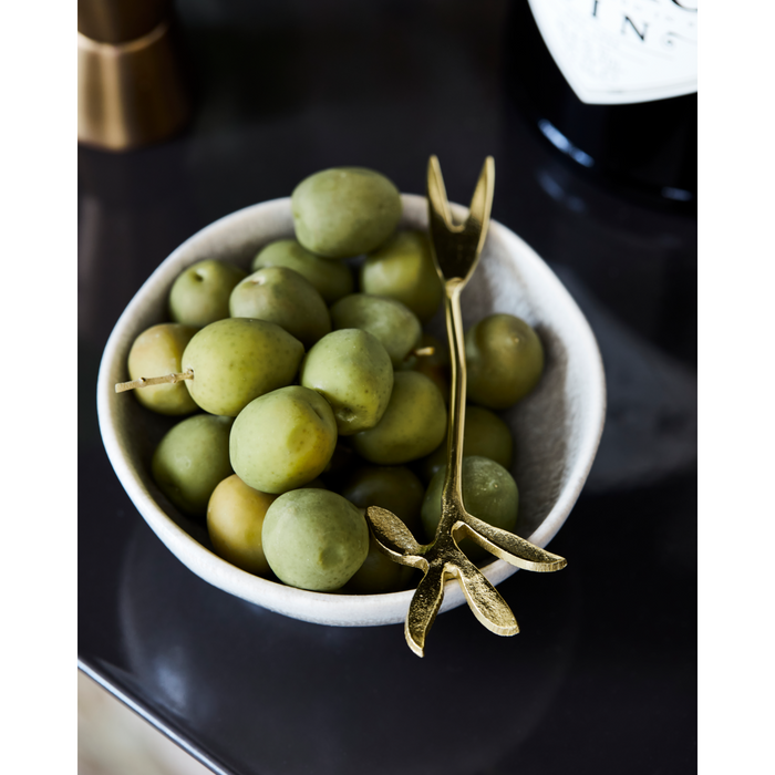 House Doctor gold fork resting in a bowl of olives