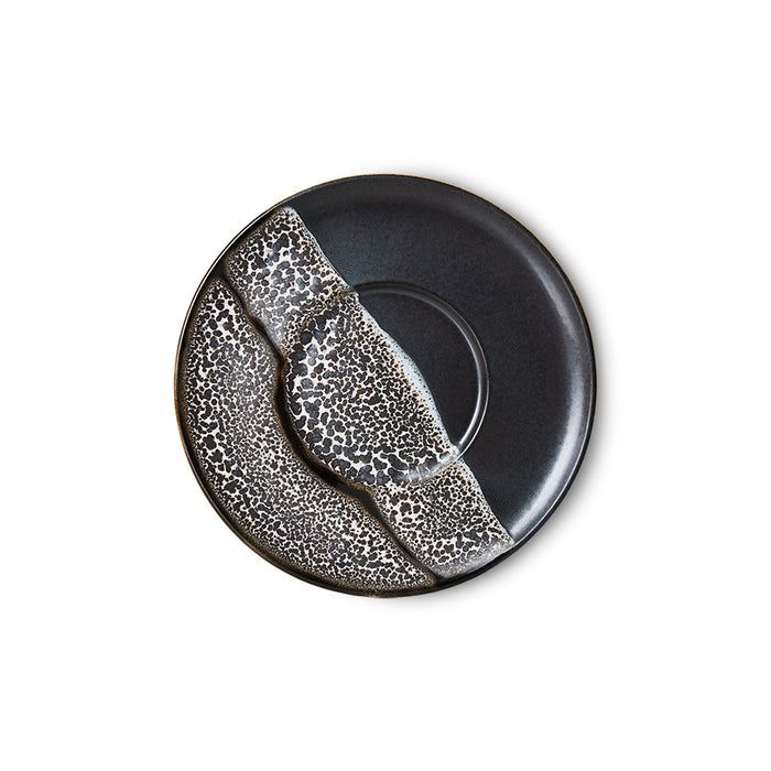 the black and white saucer that looks almost like waves that have crashed onto a beach and the bubbly foam they leave behind