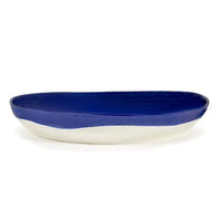 side view of the deep blue serving bowl by ottolenghi and serax where the colour oonly comes down half way on the outside revelaing the white of the ceramic underneath all generously glazed