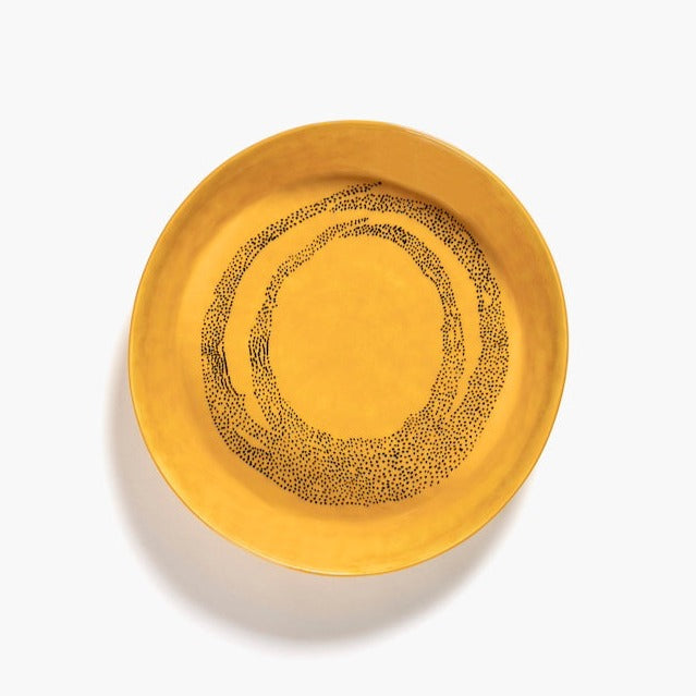 able to see inside a sunshine yellow serving dish with circles of black dots creating a captivating display with a luxurious amount of glaze from ottolenghi and serax for a real feast for the eyes