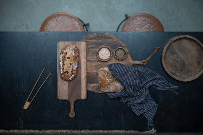 Dark wood cutting boards shown together on rustic kitchen surface