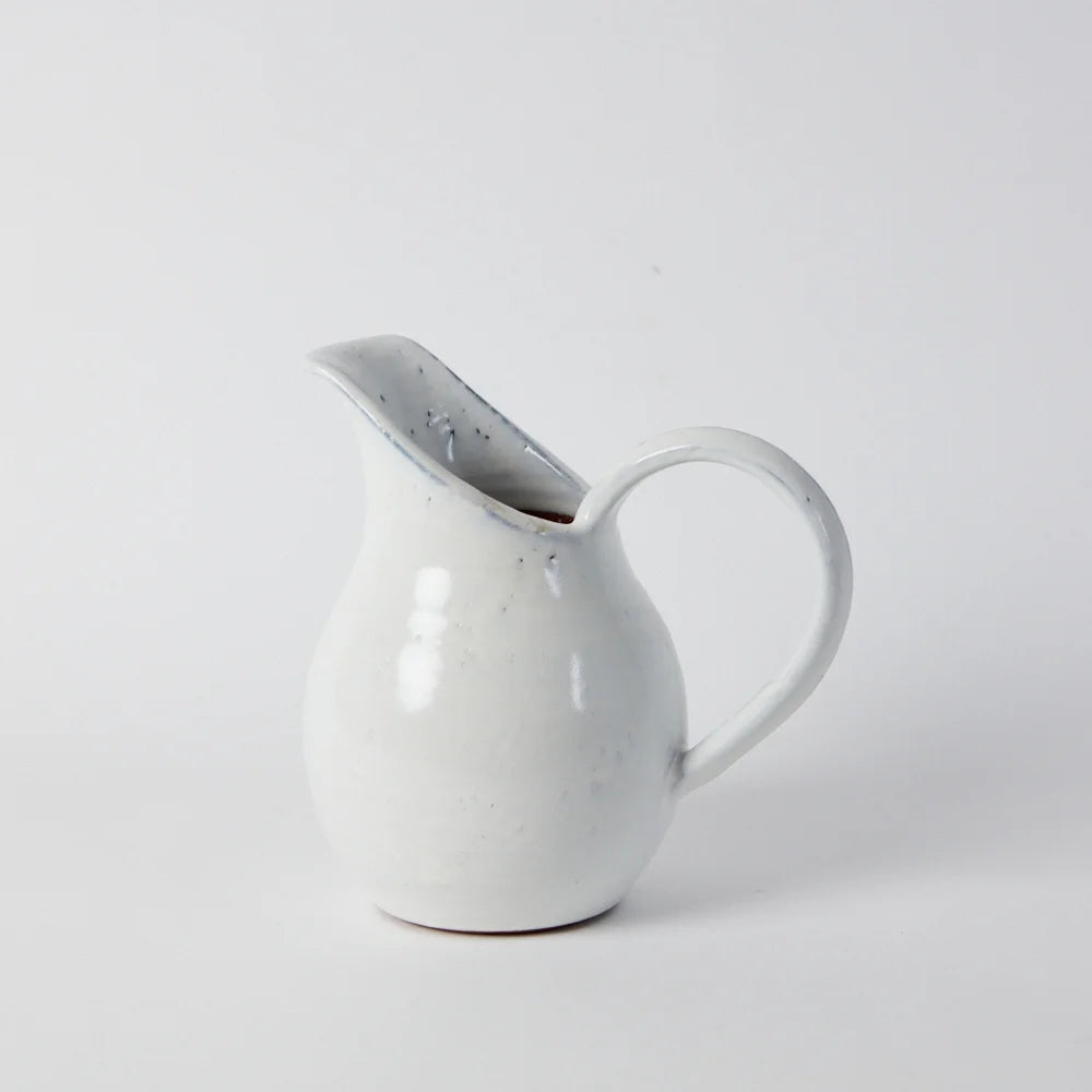 handmade clay jug with a generous white glaze and a tall long spout