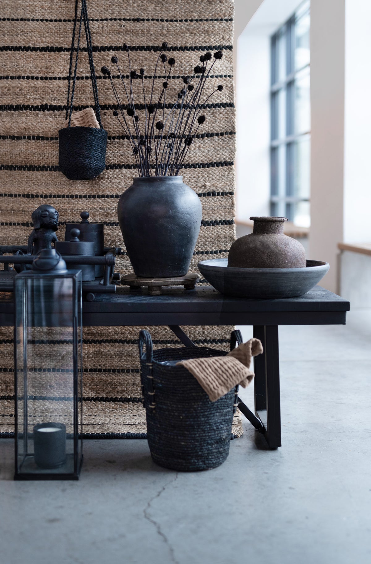 Sculptural black wooden jar with rounded shape and lid
