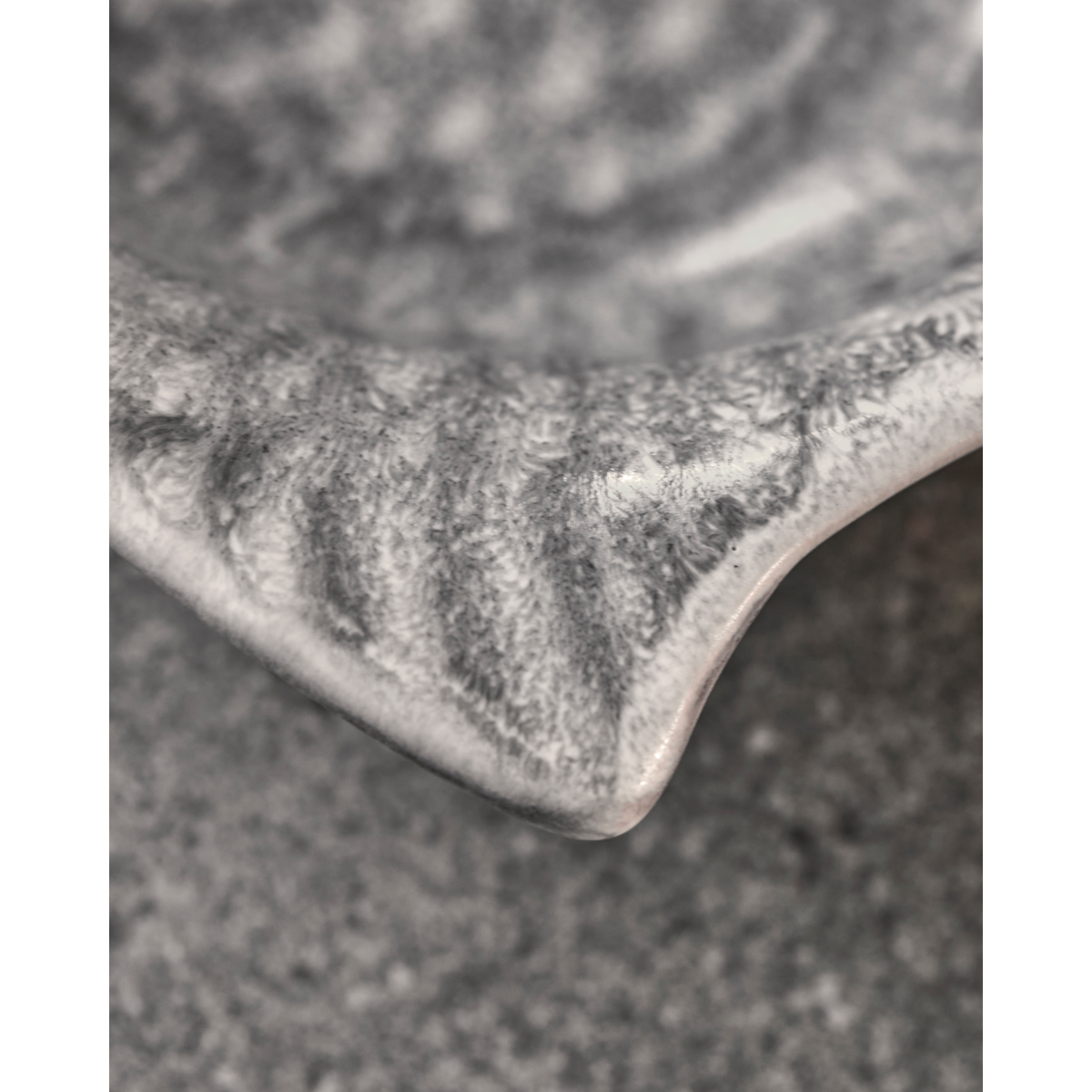 Close-up of handmade ceramic fish bowl with matte grey glaze