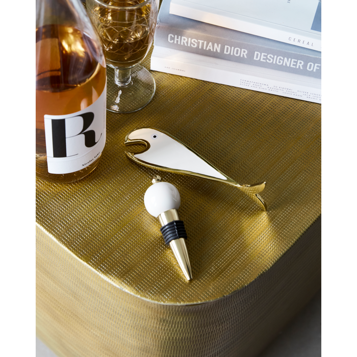Fish bottle opener and bottle stopper set styled on a gold textured surface