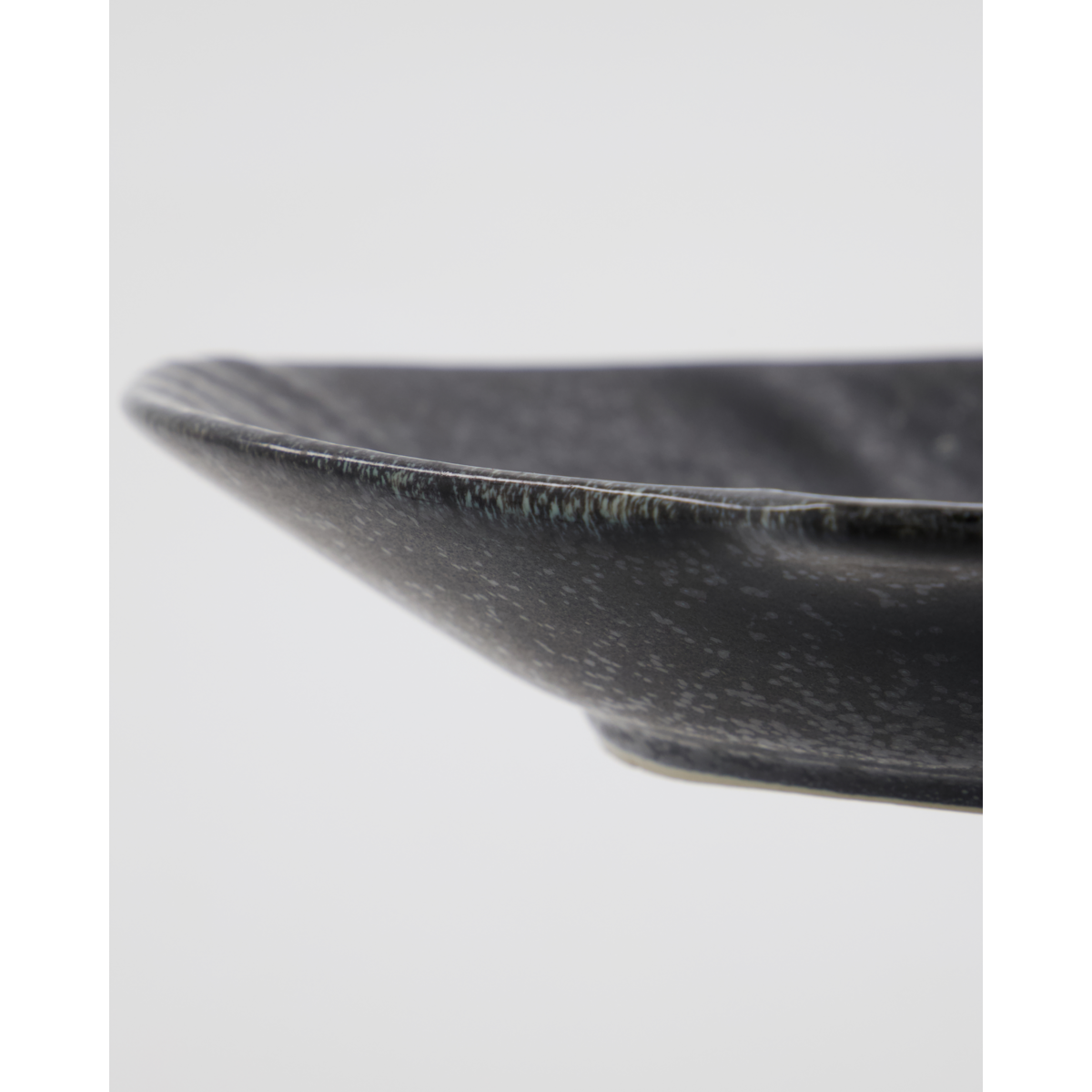 Close-up of textured black ceramic fish serving bowl by House Doctor