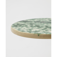 Edge view of round green stoneware board with hand-glazed finish