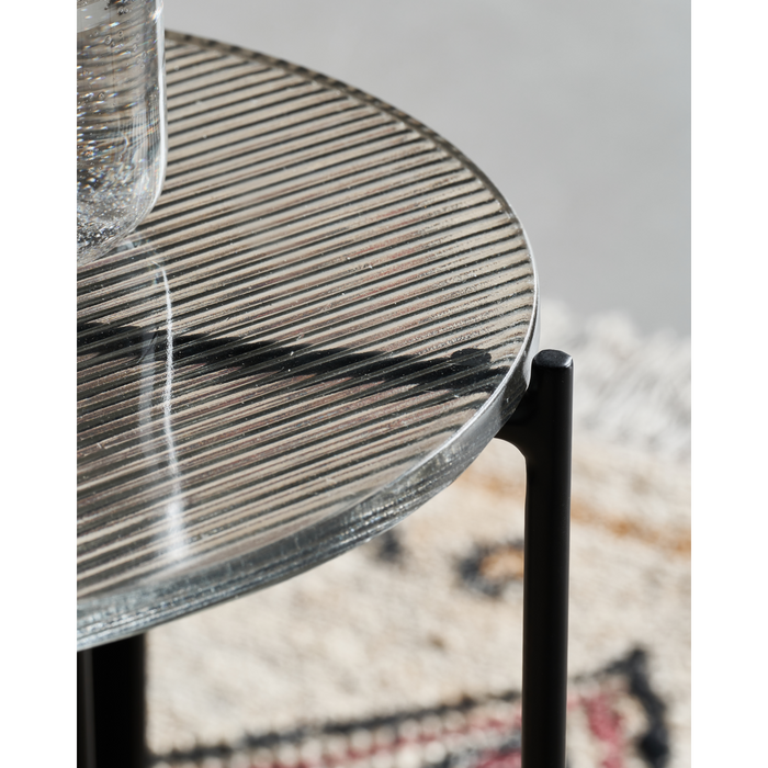 Close-up of the ribbed glass top on the Tamu black side table by House Doctor, highlighting texture and reflection