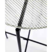 Diagonal close-up of the ribbed glass tabletop and slender leg frame of the House Doctor Tamu table
