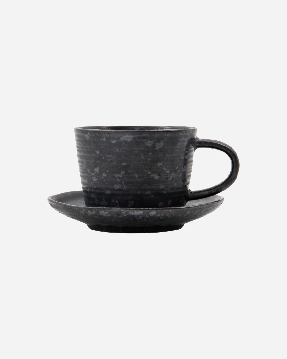 Minimalist stoneware cup and saucer in black and brown tones.