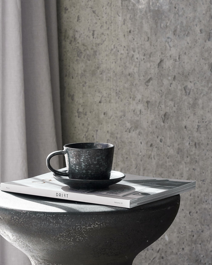 Nordic-style Pion cup with saucer in black/brown finish.