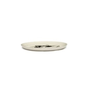 side view of an off white glazed plate by ottolenghi and serax showing can mix the different colours and designs to create an amazing collection