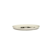 side view of an off white glazed plate by ottolenghi and serax showing can mix the different colours and designs to create an amazing collection