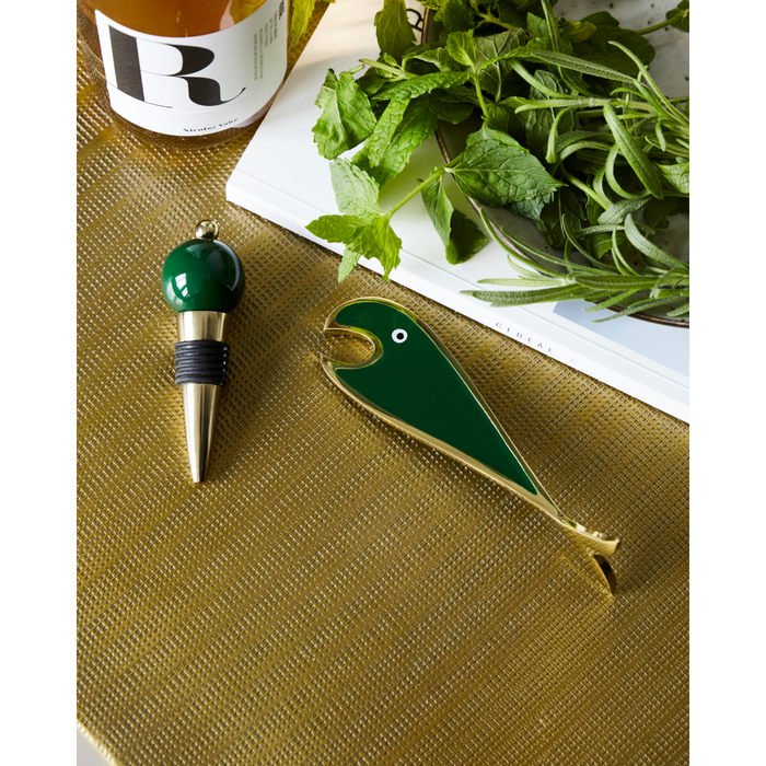 Glossy green bottle stopper and quirky fish opener styled with herbs