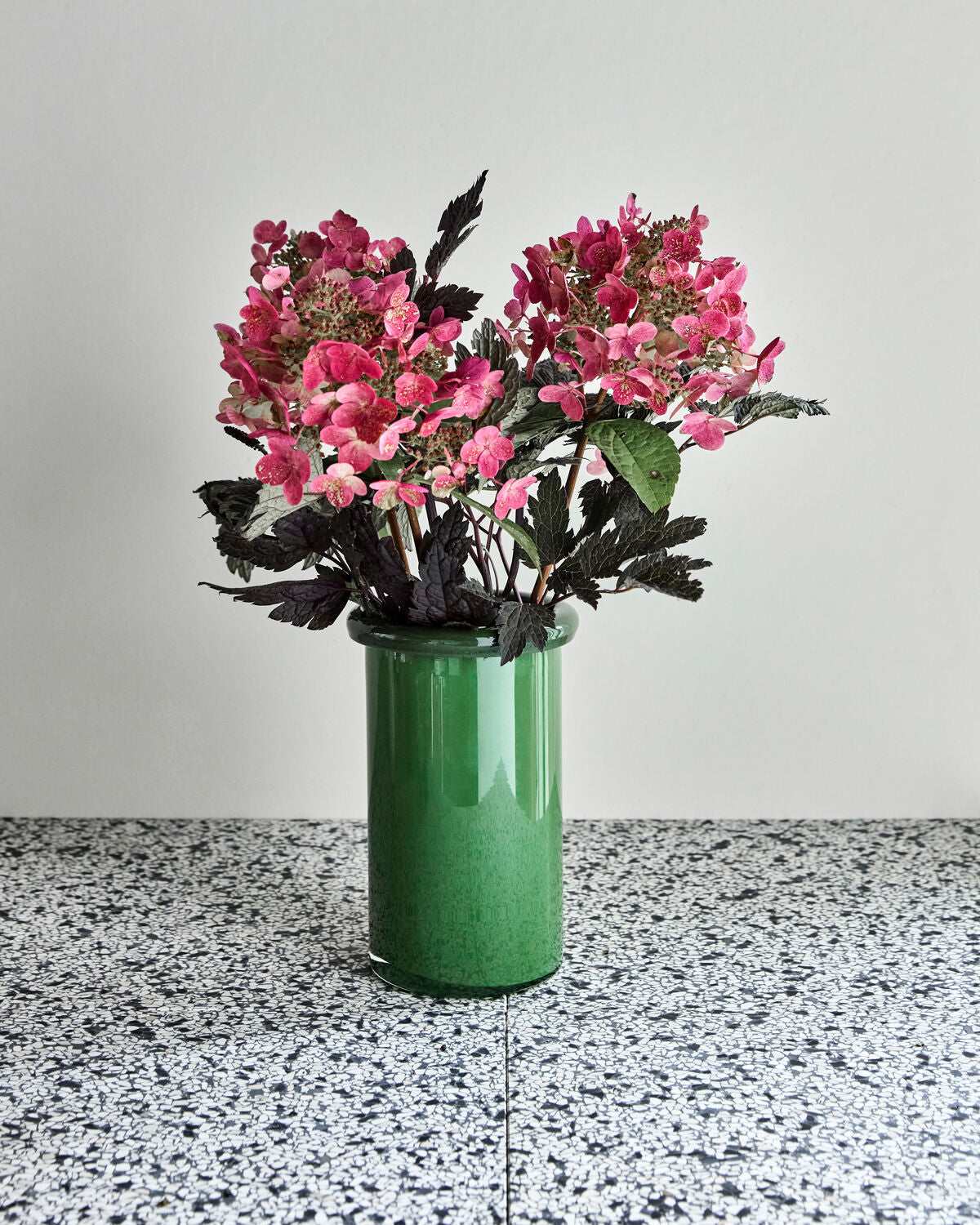 House Doctor Buck green glass vase styled with pink hydrangeas