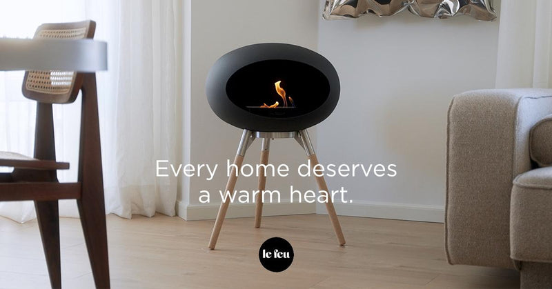 Le Feu Dome Ground bioethanol fireplace with black dome and oak legs creating warm Scandinavian atmosphere in a modern living room: Every home deserves a warm heart