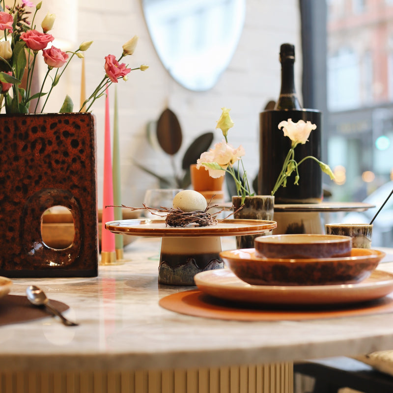 A glimpse of Nordic-inspired dining: a beautifully curated table featuring hand-crafted tableware in playful colors and clean lines. Discover the joy of everyday dining with Northhome.uk