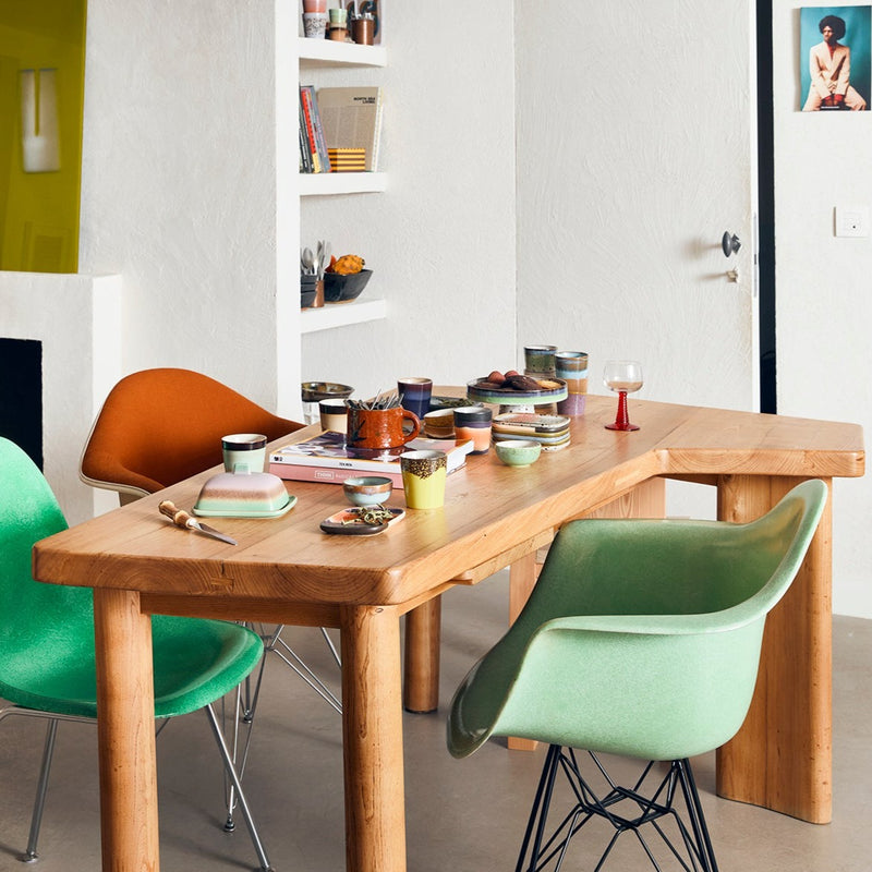 a table laid out with a number of crockery pieces from the colourful hk living 70s collection including the butter dish mugs and glasses. the door in the background is disturbingly a jar.