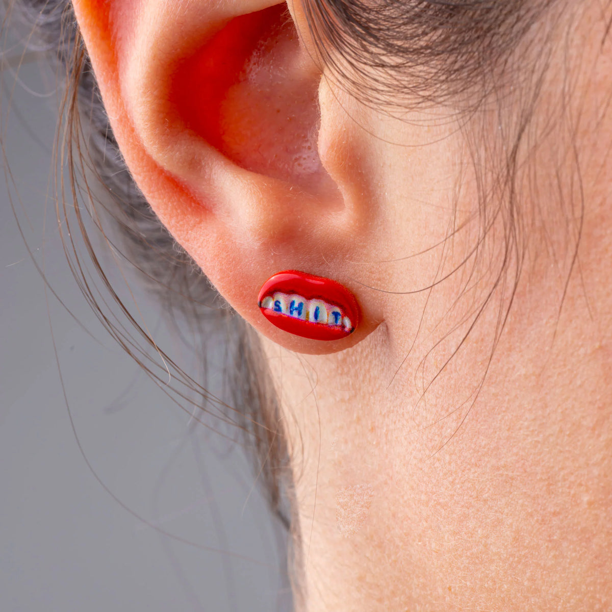 Seletti Toiletpaper SHIT stud earring in gold with red lips, worn on ear, 12mm
