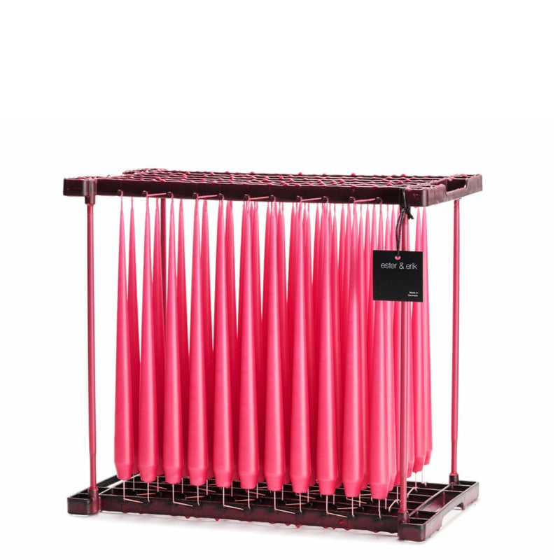 Deep pink taper candles on dipping rack