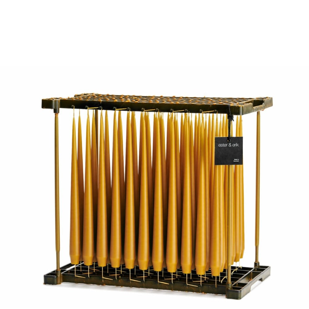 Warm amber coloured taper candles in dipping rack