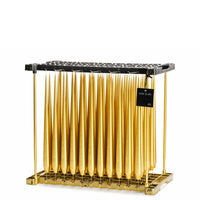 Metallic gold taper candles in dipping rack