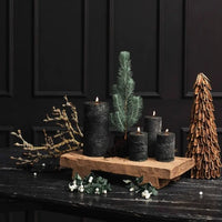 display of pillar candles on a marble side table: very festive with a tree and a sprig of a fir tree