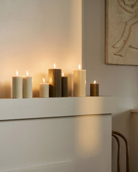 single beige pillar candle by Nordal on a white background, tall cylindrical shape with a single wick