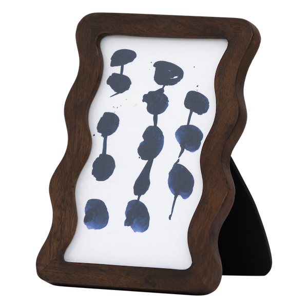 small wavy wooden photo frame styled on shelf with ceramic vases