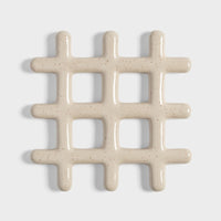 speckled beige ceramic grid trivet shown on white background
