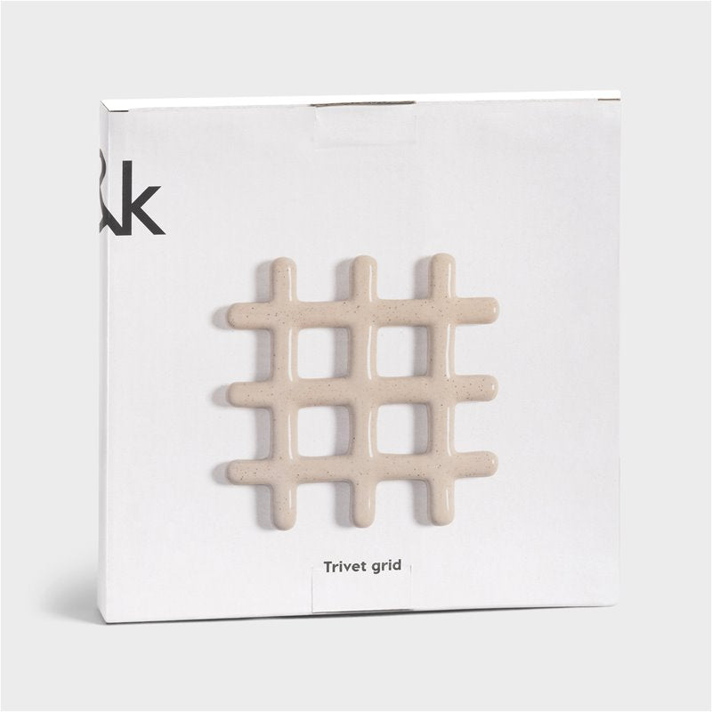 stoneware grid-shaped trivet in speckled beige shown in giftable packaging
