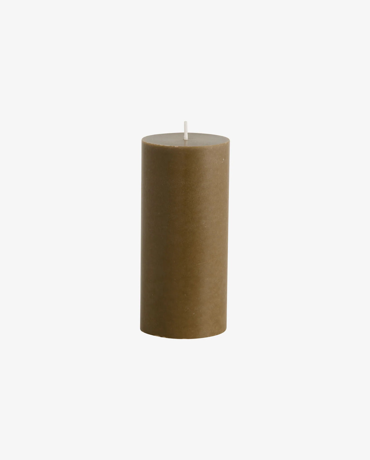 lit dark olive green and cream Nordal pillar candles on a white radiator cover, with a spiky cream ceramic dish, a dark textured rock ornament and a matchbox alongside