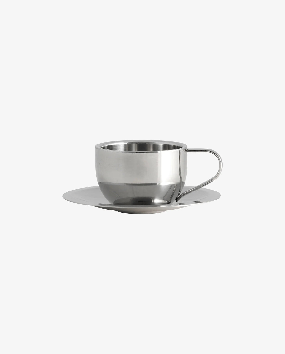 Close-up of the VIREA chrome cup and saucer by Nordal with coffee, on a dark wood table