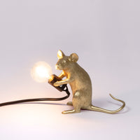Seletti Gold sitting Mouse Lamp switched on, with a warm glowing bulb
