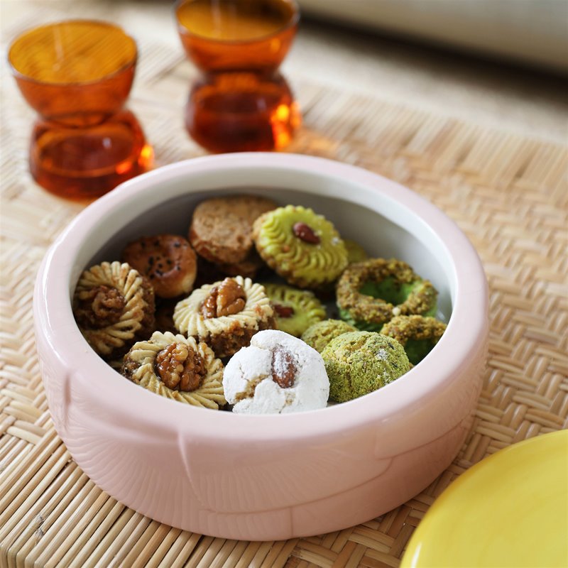 alt text: pink ceramic jar with contrasting yellow lid filled with assorted biscuits by &k