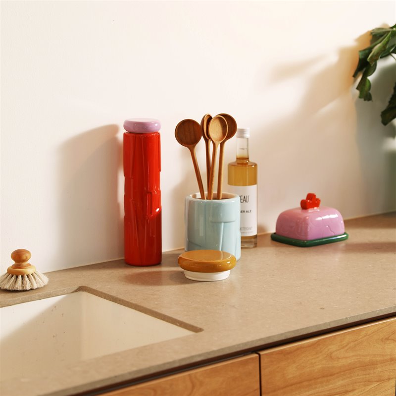 colourful blue and mustard ceramic storage jar styled on a modern kitchen countertop
