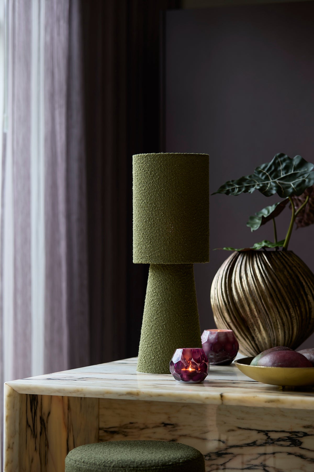styled living room scene with olive green boucle table lamp on marble table
