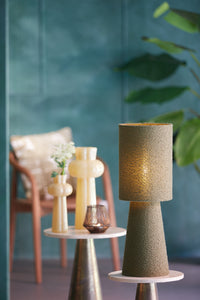 olive green boucle table lamp styled in calm interior with blue wall

