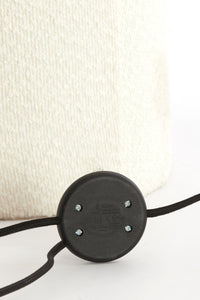 Close-up of a black circular component with screws on a white background