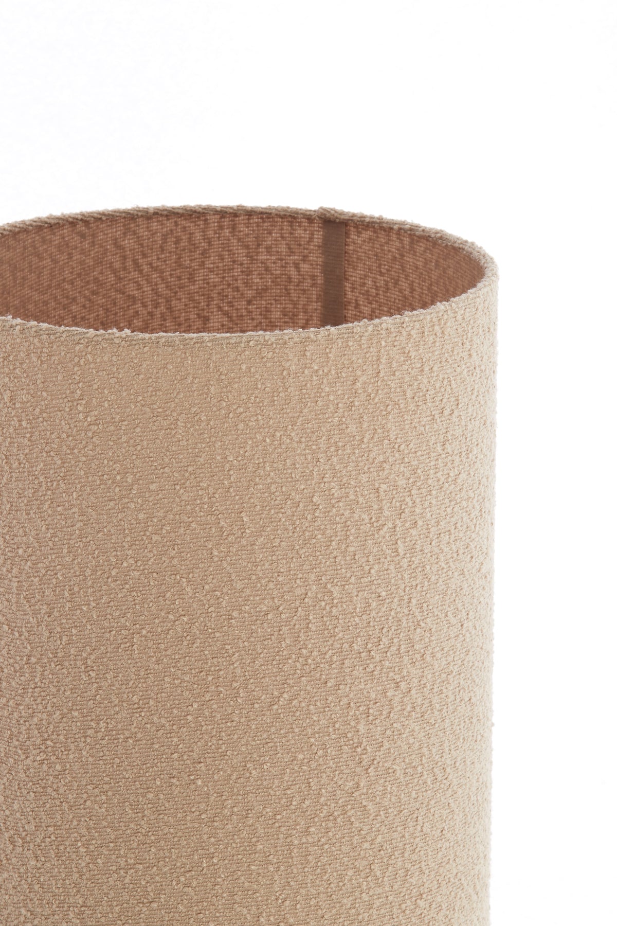 Close-up of a textured cylindrical lam shade with a brown interior on a white background