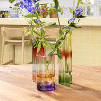 tall gradient glass vases by &k styled with flowers on a wooden table
